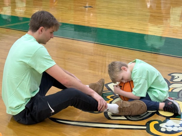 Maddux Boone, 7, of Tinley Park, hugs a basketball rolled to him by Providence's Luke Rost Friday, Jan. 2, 2026, at the Super Celtics Special Needs Coed Camp in New Lenox. (Jeff Vorva/for the Daily Southtown)