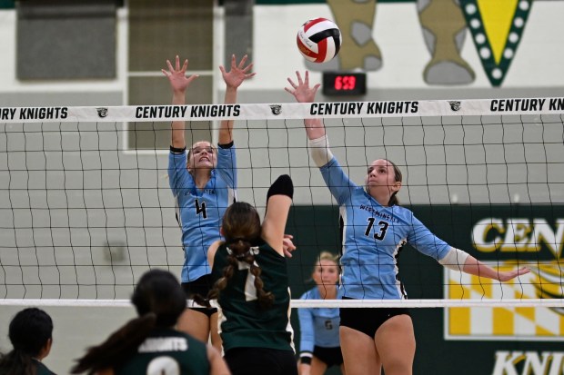 Westminster's Jaiden Hammel, left, and Allie Ryan try to block the ball during a volleyball game at Century High School. (Thomas Walker/Freelance)