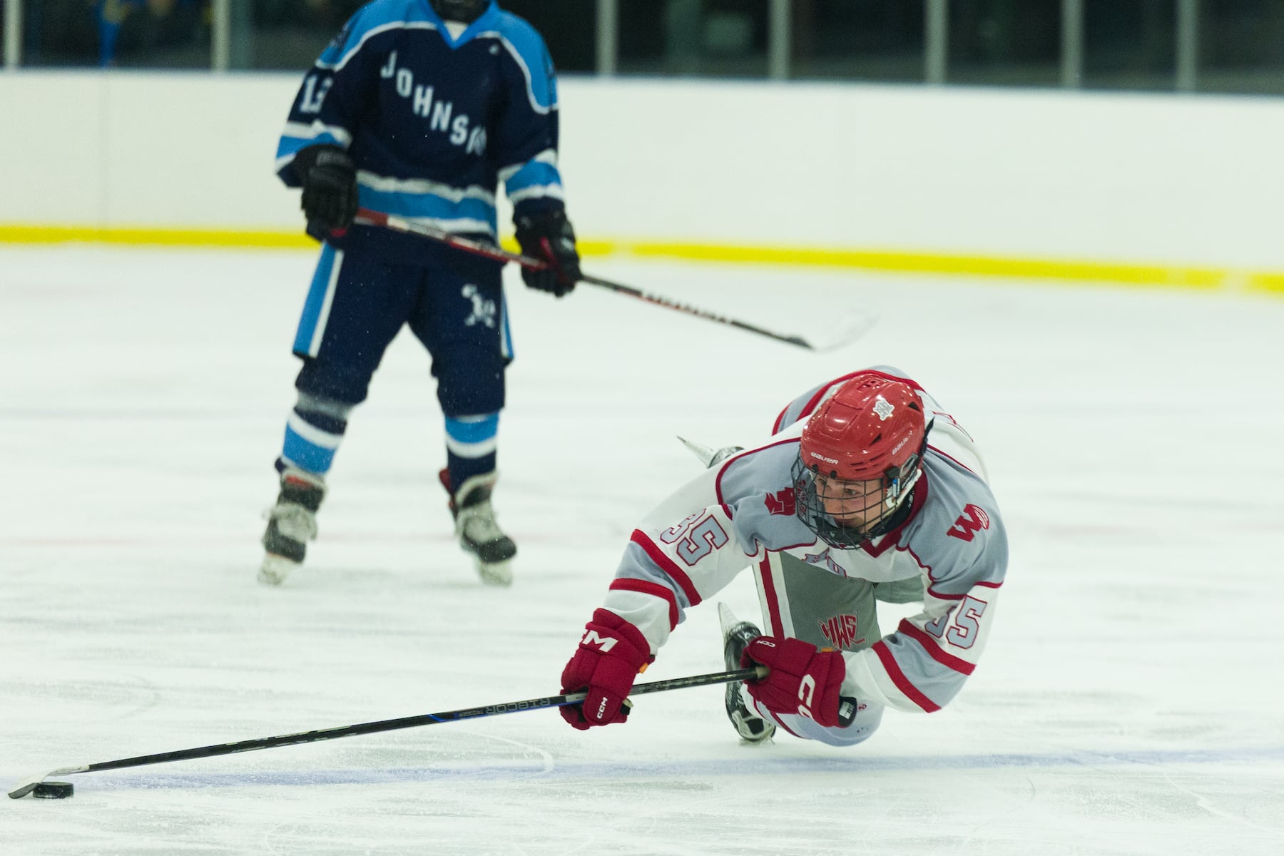 Luca Matullo of Hoboken (35) goes to the ice to grab the puck from A.L. Johnson in Sunday's high school boys ice hockey showdown in Roselle. Johnson out-skated the Redwings 4-1.  01/11/2026