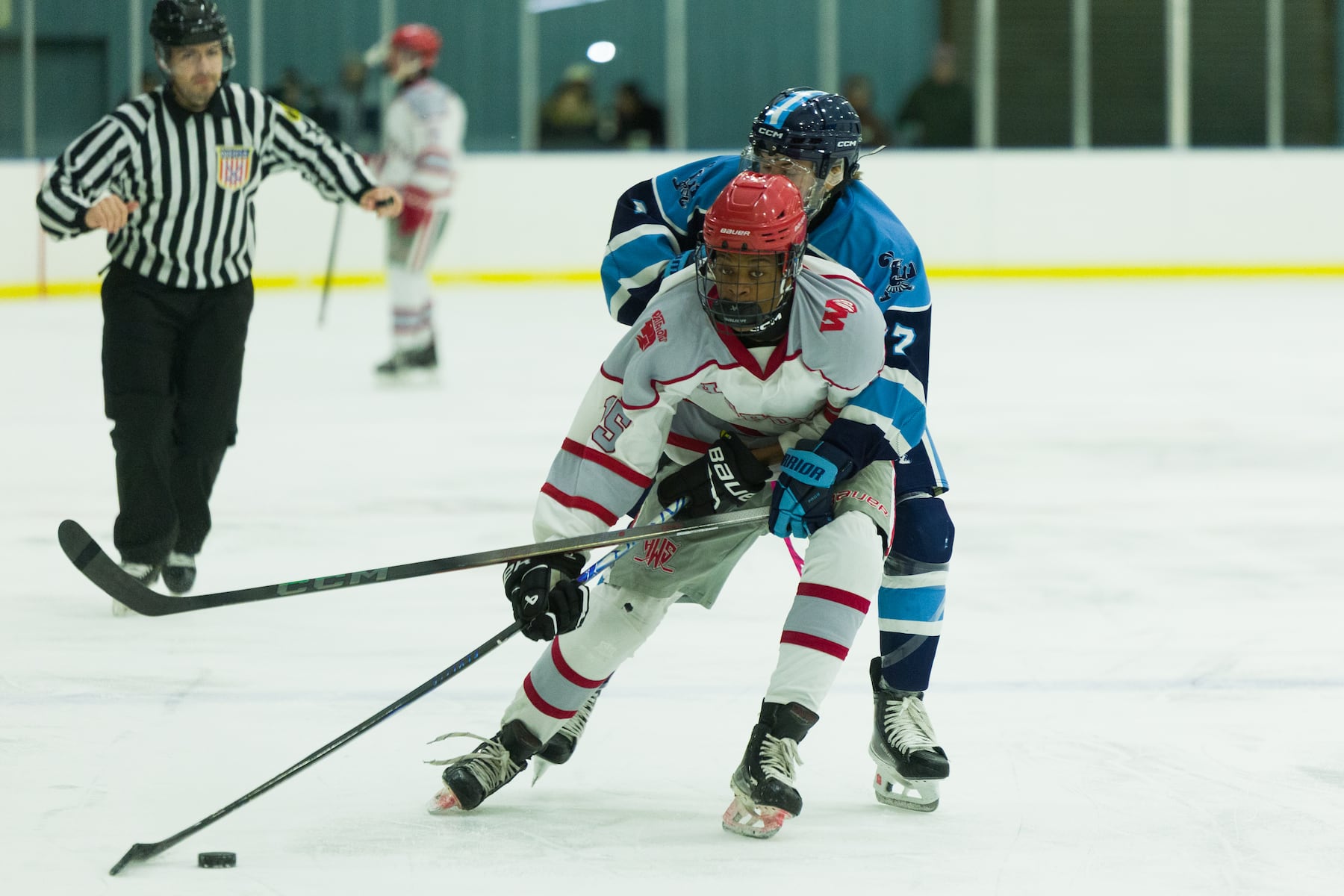 Phoenix Womack of Hoboken (15) tries to keep the puck from Grant Kalikas of A.L. Johnson (7) in Sunday's high school boys ice hockey showdown in Roselle. Johnson out-skated the Redwings 4-1.  01/11/2026