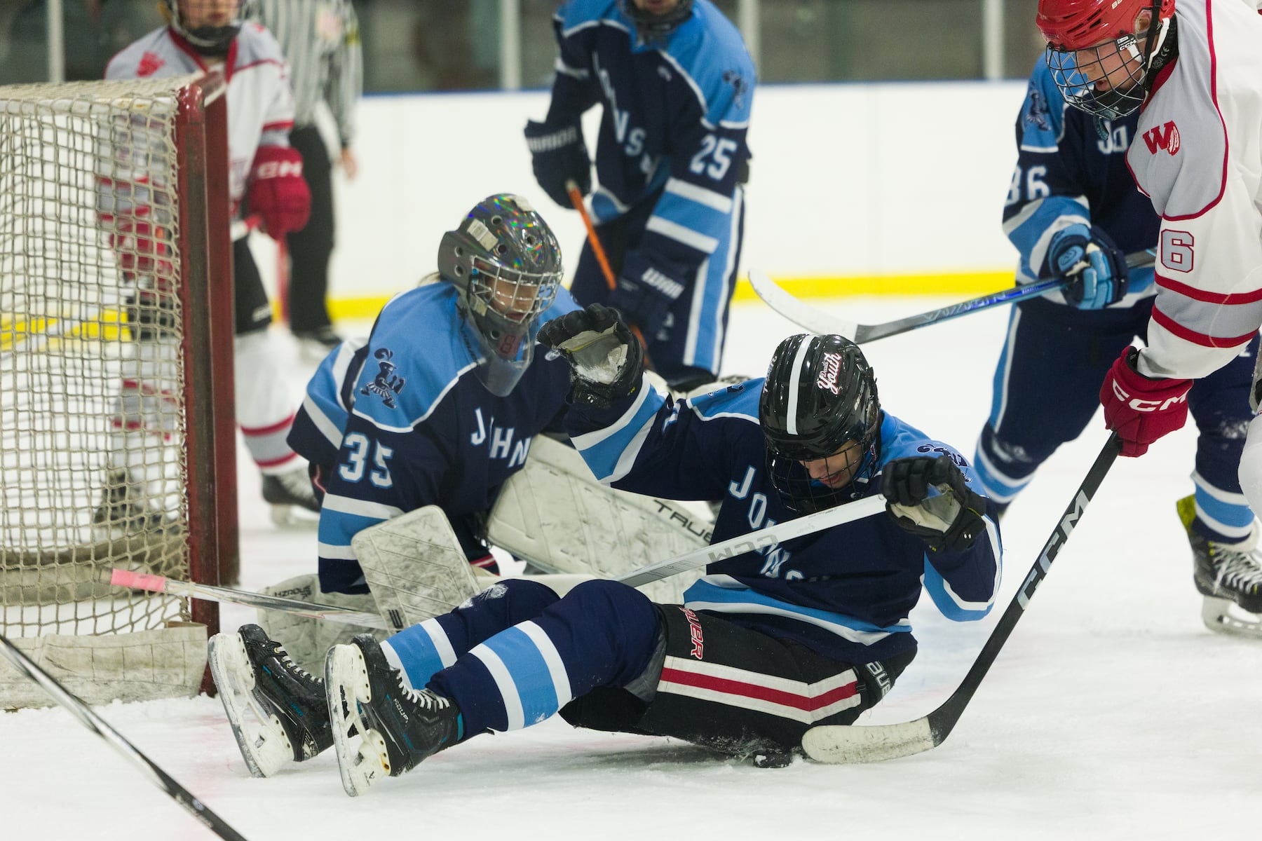 Jack Goldate of A.L. Johnson (fore) makes the defensive stop against Hoboken in Sunday's high school boys ice hockey showdown in Roselle. Johnson out-skated the Redwings 4-1.  01/11/2026