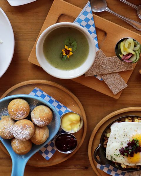 different plates of traditional Nordic brunch items arranged on a wooden table