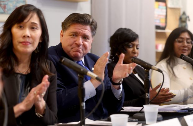 Deputy Gov. Grace Hou, left, and Gov. JB Pritzker participate in a roundtable discussion on Jan. 20, 2026, with Illinoisans, including Daphne Williams and Maritza Patricio-Guzmán, on the impact of funding cuts during the first year of Trump's second presidential term. (Antonio Perez/Chicago Tribune)