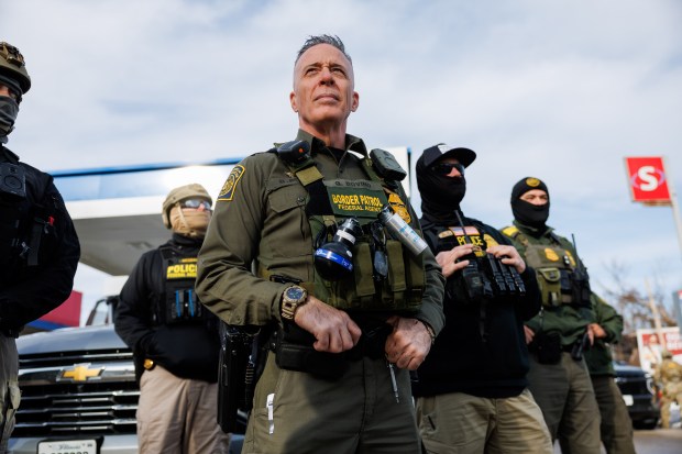 People yell at U.S. Border Patrol Cmdr. Gregory Bovino and other agents while they stop at a gas station while conducting an immigration enforcement action, Dec. 17, 2025, in Evanston. (Armando L. Sanchez/Chicago Tribune)