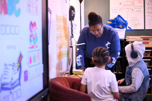 Aspiring Educator Amaya Mills, top, works with first graders in a reading class at Ponderosa Elementary School in Aurora, Colorado on Tuesday, Oct. 29, 2024. (Photo by Hyoung Chang/The Denver Post)