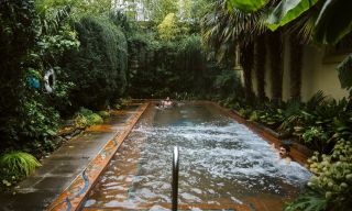 a man enjoying a warm water, outdoor pool