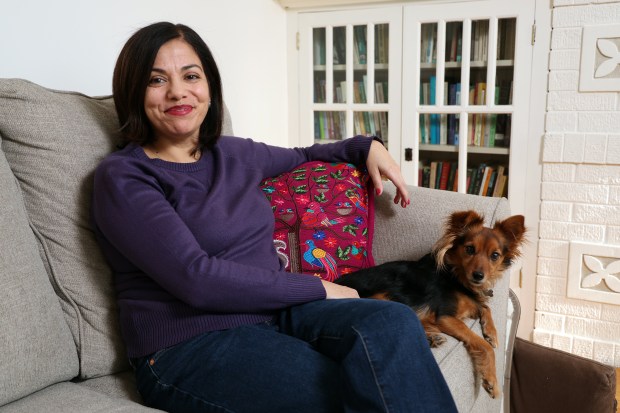 Daisy Hernández, an associate professor of creative writing at Northwestern University, relaxes at home in Chicago with her dog Lula, Jan. 23, 2026. (Terrence Antonio James/Chicago Tribune)