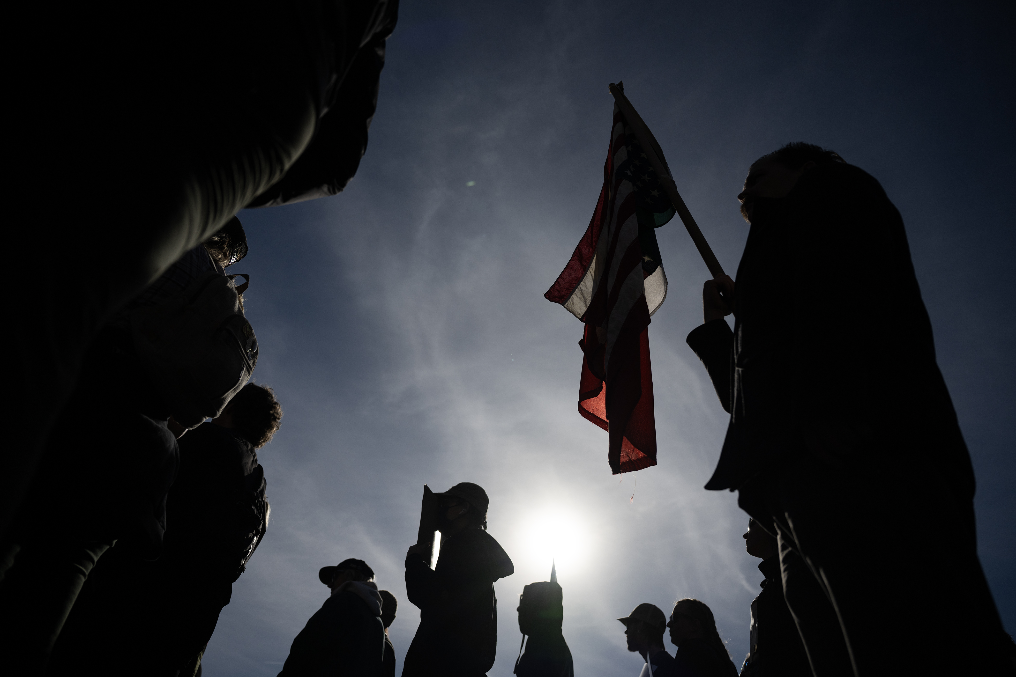 A protestor holds a U.S. flag, hung upside down, during...
