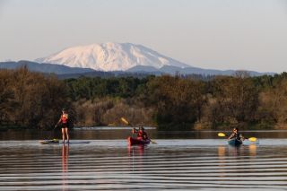 Kayakers and a stand-up paddle boarder ply the waters of Scapoose Bay
