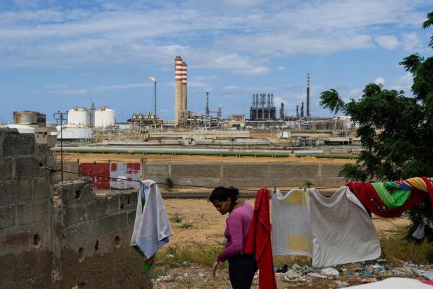 A woman who lives near the Cardon refinery hangs clothes to dry in Punto Fijo, Venezuela