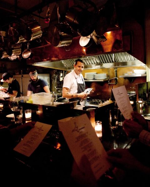 a chef stands in a small open kitchen