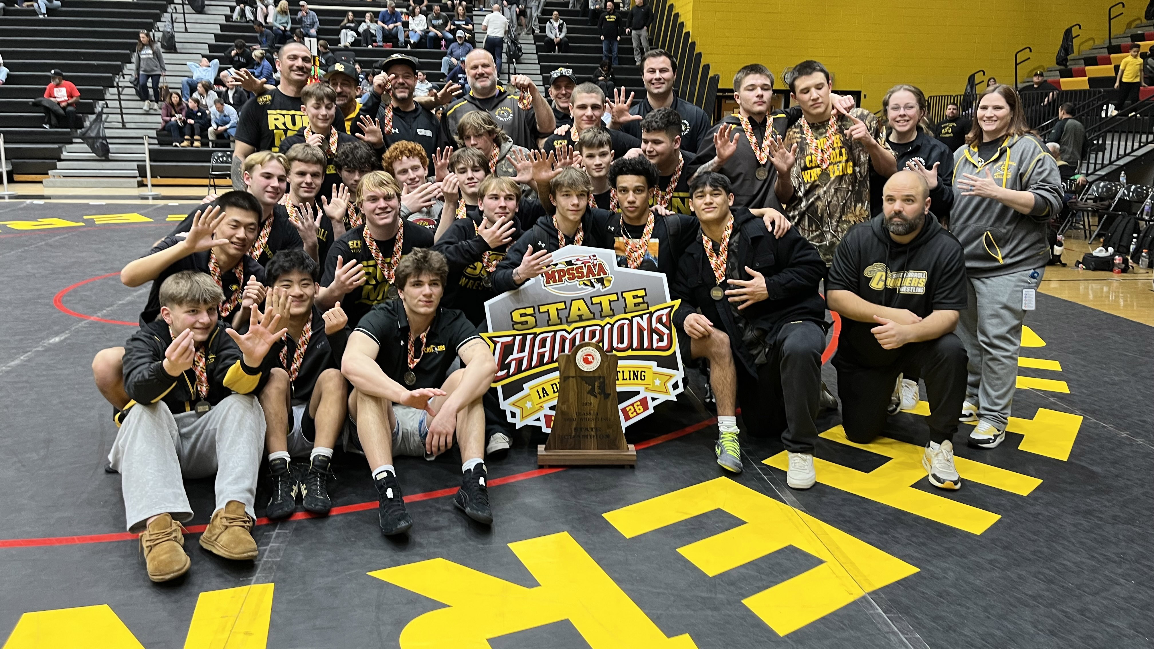 South Carroll's wrestling team celebrates their championship following their win...