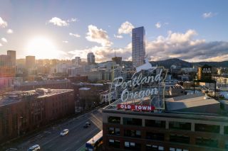 city view of downtown area with rolling hills in the background as the sun sets