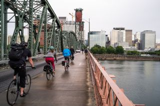 bikers and pedestrians on Hawthorne bridge with grey skies and wet pavement