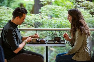 A couple sits enjoying tea service.