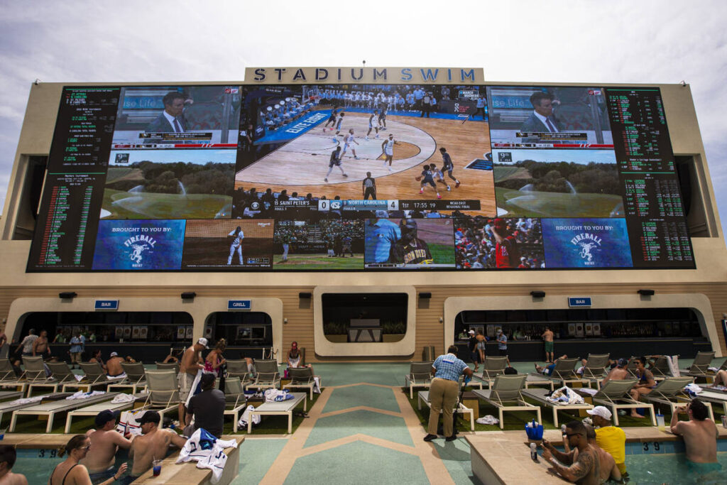 People watch the NCAA tournament at Stadium Swim at Circa on Sunday, March 27, 2022, in downtow ...