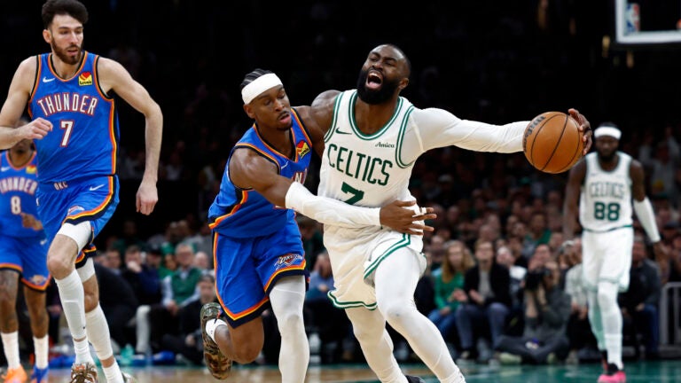 Oklahoma City Thunder guard Shai Gilgeous-Alexander (2) fouls Boston Celtics guard Jaylen Brown (7) during the fourth quarter at TD Garden on March 25, 2026 in Boston.