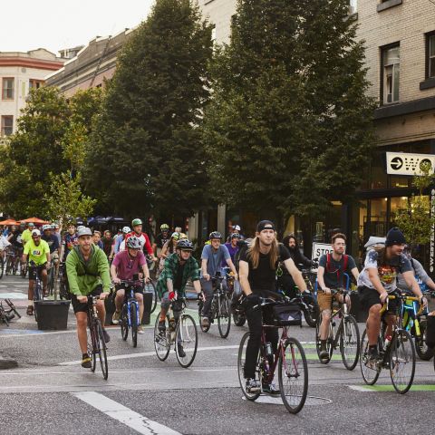 a group of cyclists ride together ona protected street