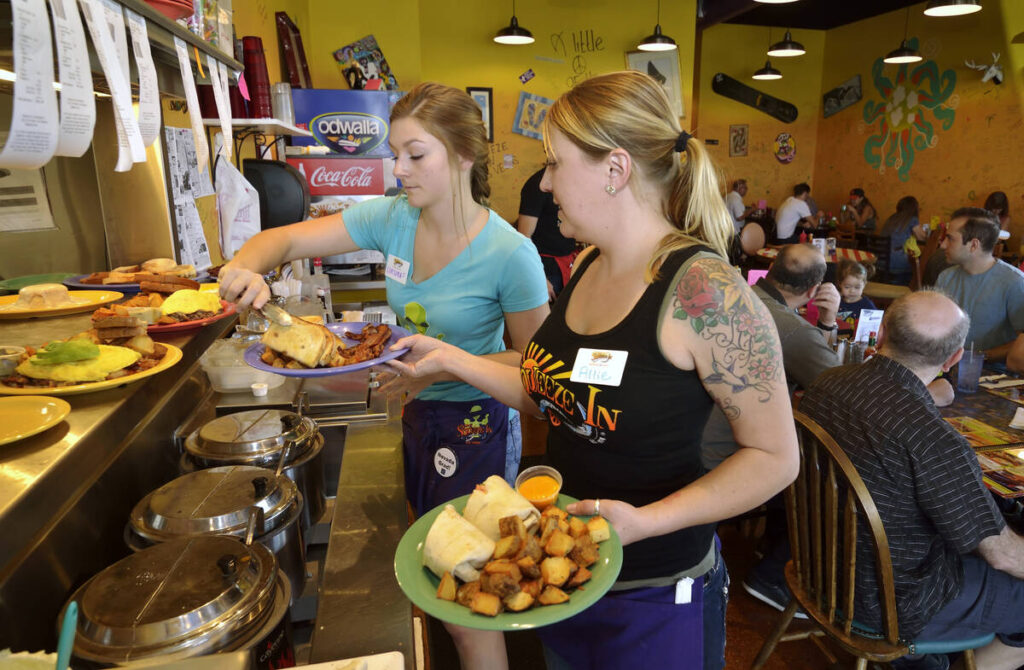 Hostess Chelsea Pond, left, and general manager Allie Duby work to get food orders to customers ...