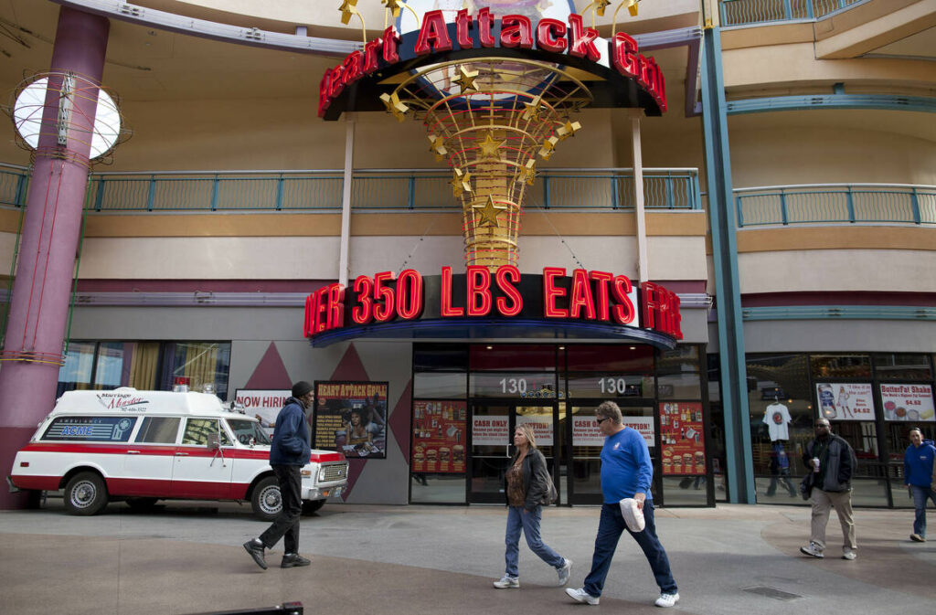 Pedestrians pass by the Heart Attack Grill on Fremont Street, Wednesday, Feb. 15, 2012, in Las ...