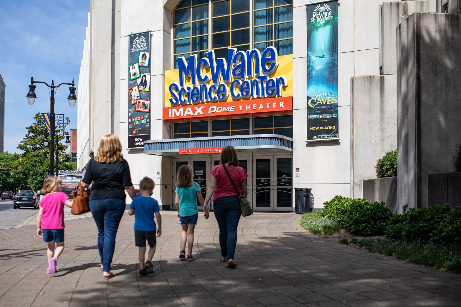 20 weekend events including the Alabama State Games (June 12-14) 4 Two adults and three children walking toward the entrance of McWane Science Center and IMAX Dome Theater in Birmingham
