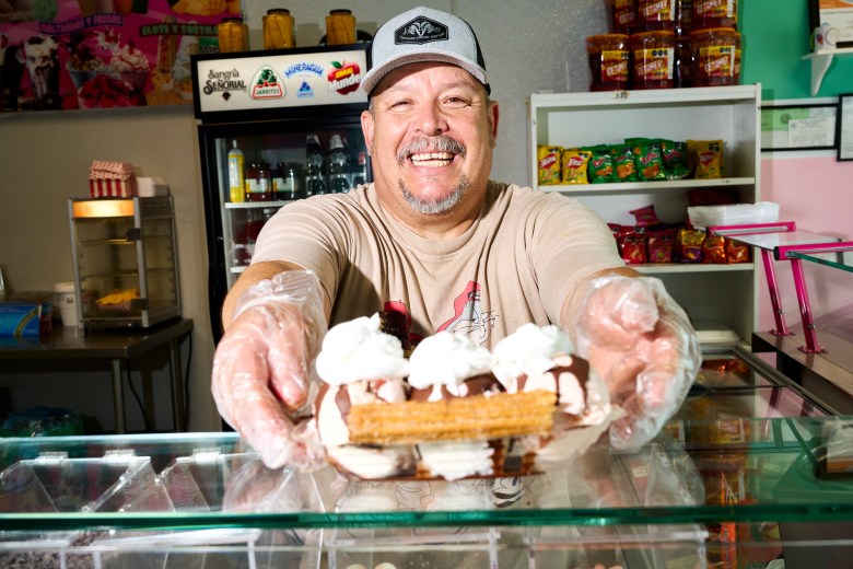 Owner Carlos Torres hands over a churro sundae at Vida Dulce. Photo by Matt Ramey.