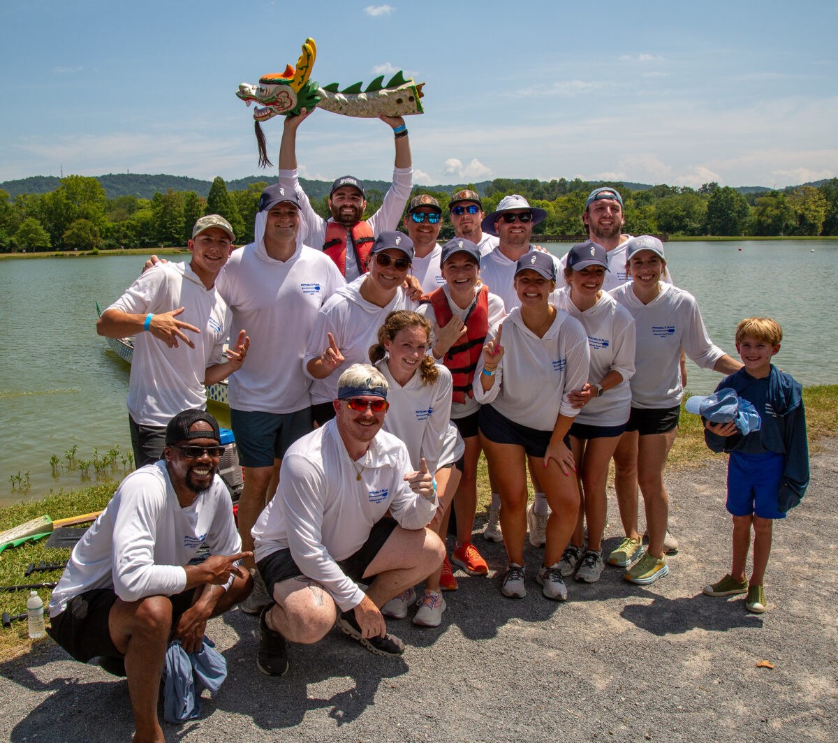 FREE Dragon Boat Race and Festival returns Aug 8—how to experience it 5 A Mitchell's Place dragon boat team poses together at East Lake Park, one member holding up a decorative dragon boat figurine