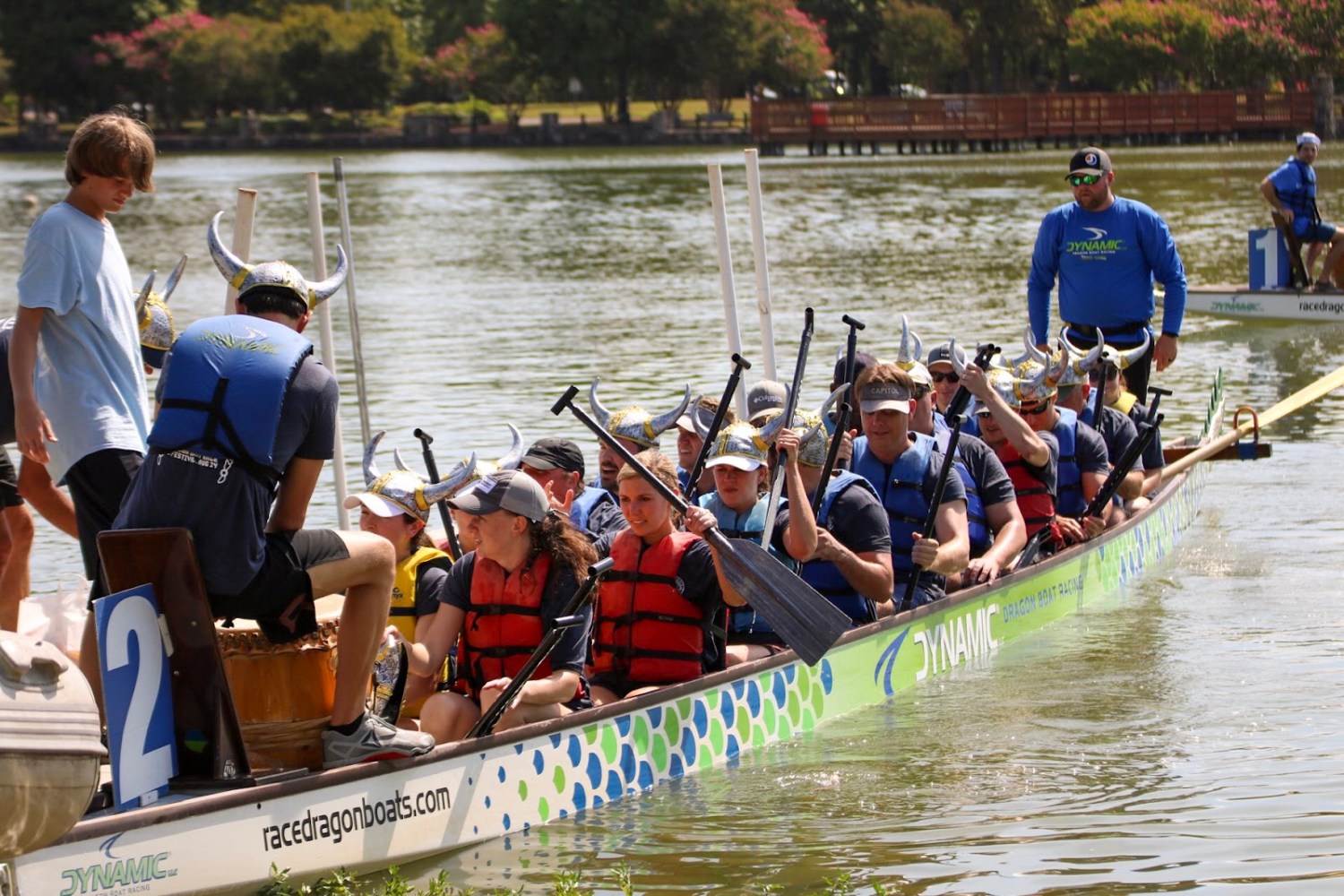 FREE Dragon Boat Race and Festival returns Aug 8—how to experience it 7 A team wearing Viking helmets and life jackets paddles a dragon boat on East Lake Park during the Mitchell's Place Dragon Boat Race Festival