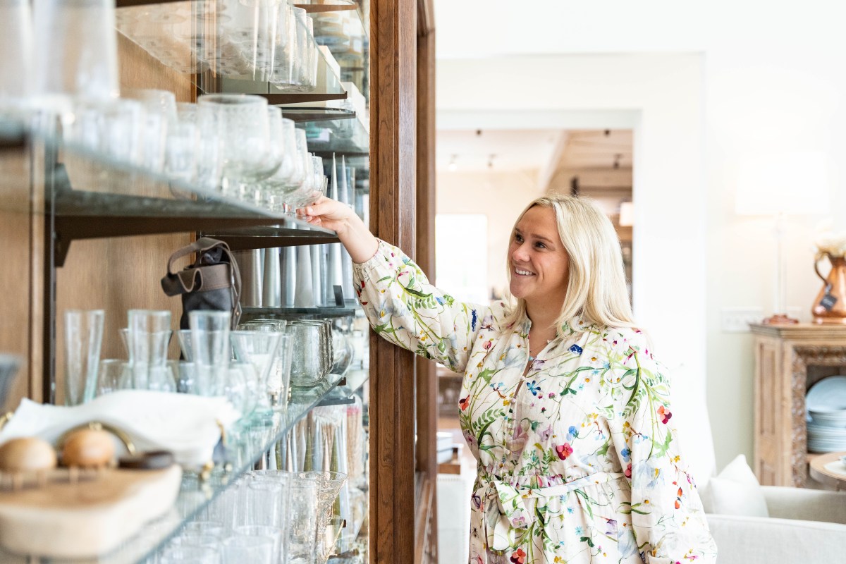 Plan now for these 34 weekend events: July 16-19, 2026 2 A smiling woman in a floral dress browses glassware on shelves inside Christopher Collection in Homewood