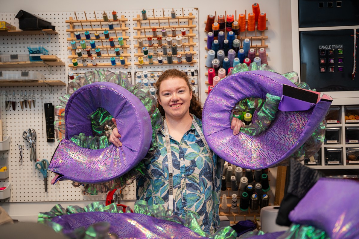 Plan now for these 34 weekend events: July 16-19, 2026 6 A costume designer holds large purple iridescent shell-shaped costume pieces in Red Mountain Theatre's costume shop