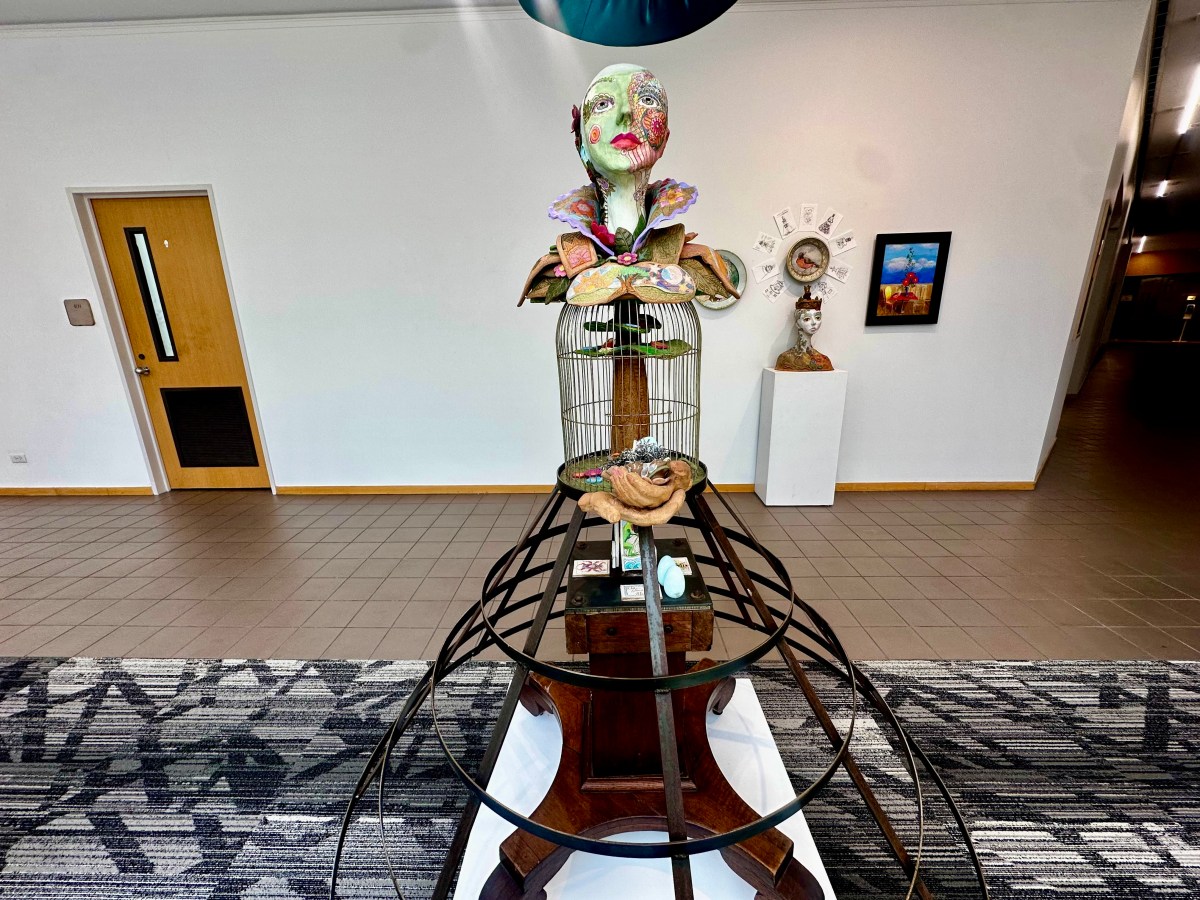 Sculptural dress installation featuring a painted bust atop a birdcage bodice and hoop skirt frame, displayed in the Fourth Floor Gallery at Birmingham Public Library