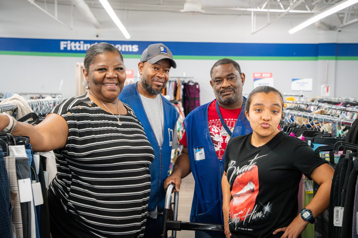 See thrifted looks strut the runway + support a great cause—Aug. 26 2 Alabama Goodwill employees Sharron Jackson, Danyell Benson, Darrell Taylor and Cuca Keeder pose together among clothing racks inside a Goodwill store