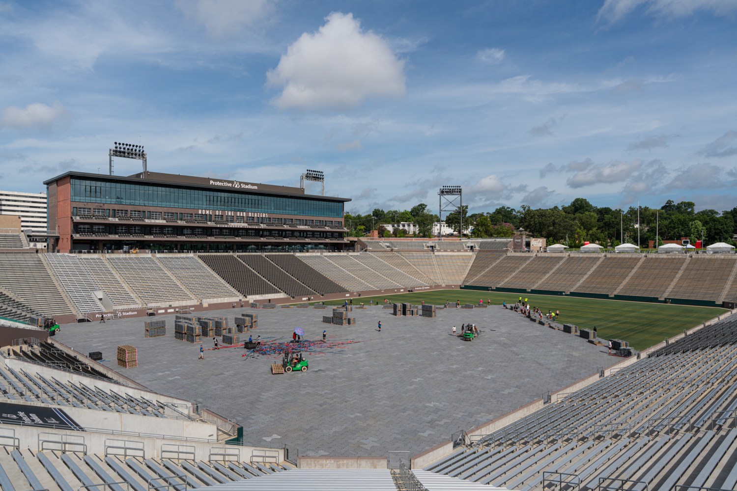 Protective Stadium, home of the UAB Blazers, with workers setting up equipment and structures on the field