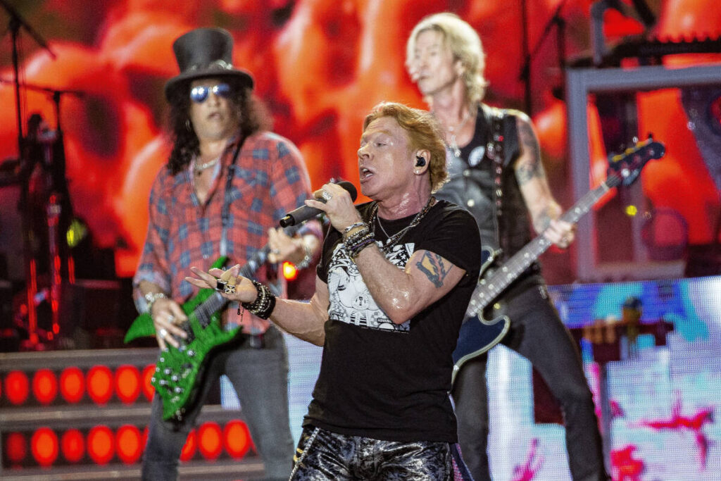 Axl Rose, center, Slash, back left and Duff McKagan, back right of Guns N' Roses perform d ...