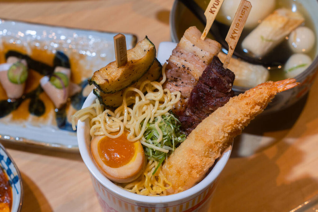 Ramen street cup and yakitori skewers from Super Kyuramen, open as of summer 2026 in Chinatown ...