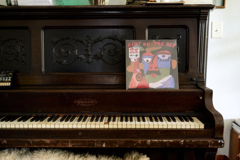 Chris Frisina created the album cover for “Riot Of The Red” for his musical act Lou Hazel. Photo by Matt Ramey.