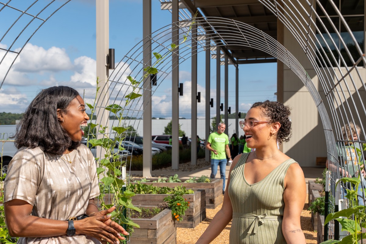 Two women talking and standing at the Shipt Community Garden at the Community Food Bank of Alabama