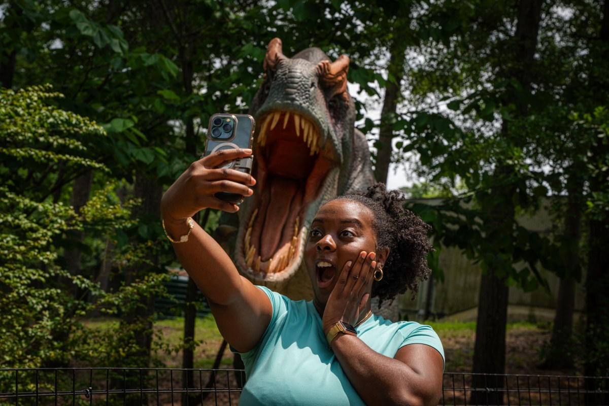 55 September Events: Birmingham Artwalk, Southbound Food Festival + more 12 woman taking a photo of herself in front of a fake roaring dinosaur