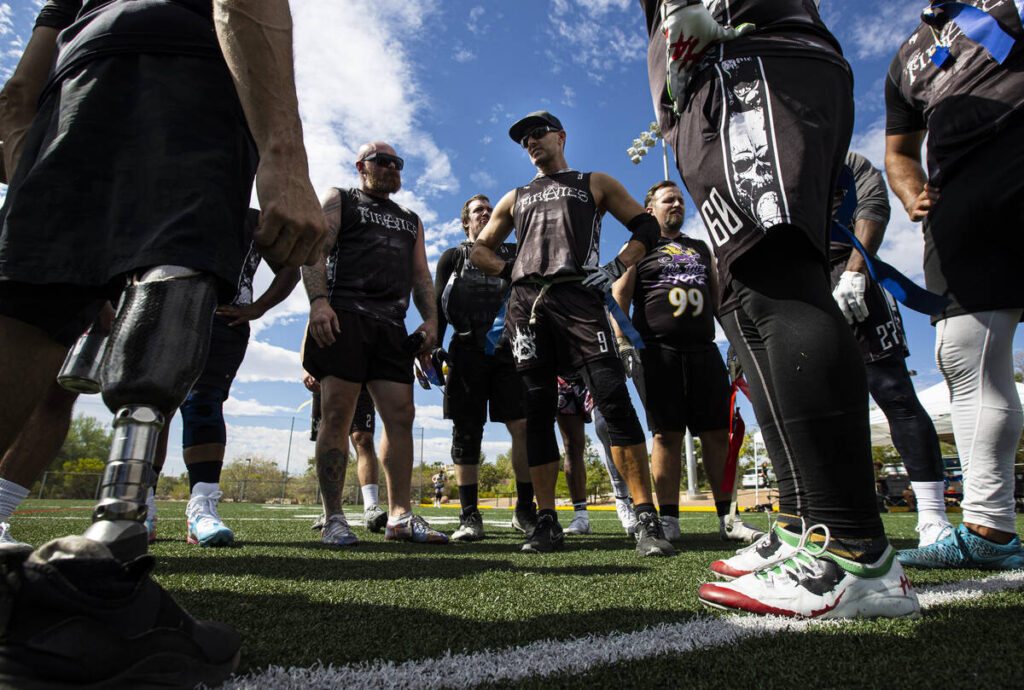 Dustin Wilder of the Pirates, center right, huddles with teammates after a flag football game a ...