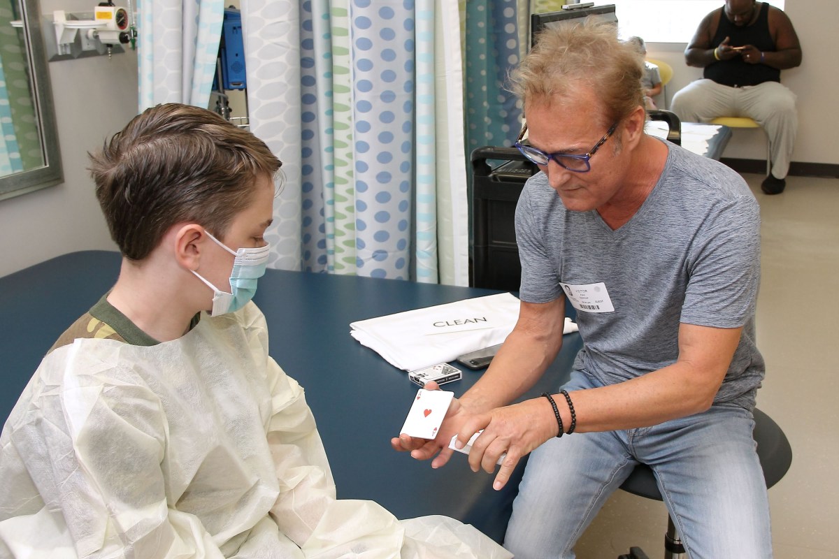 4 unique ways to champion Birmingham’s arts scene this fall 5 A magician shows a card trick to a young patient in a medical clinic during an Arts in Medicine session