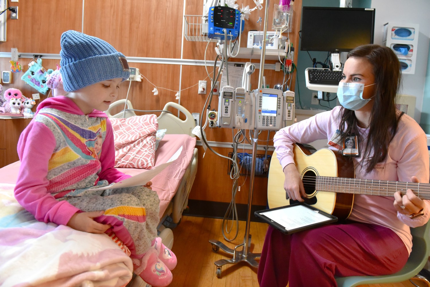 4 unique ways to champion Birmingham’s arts scene this fall 6 A masked music therapist plays guitar for a young patient in a hospital bed during an Arts in Medicine session