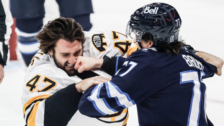 Winnipeg Jets' Tyrel Bauer (77) and Boston Bruins' Mark Kastelic (47) fight during the first period of an NHL hockey game in Winnipeg, Manitoba, Friday, Oct. 2, 2026.